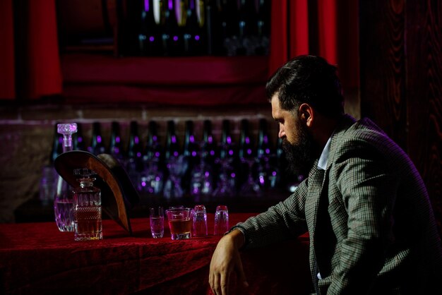 Portrait of a bearded man with a glass of alcohol in his hands Rest and relaxation in pub or bar