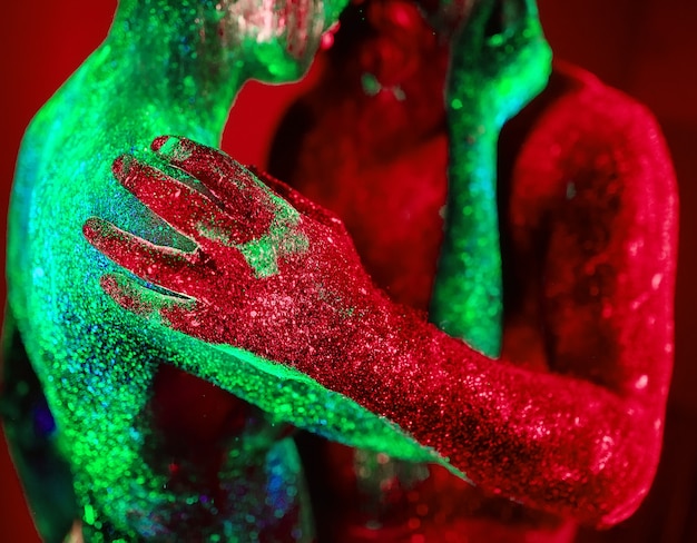 Portrait of a bearded man and woman painted in ultraviolet powder