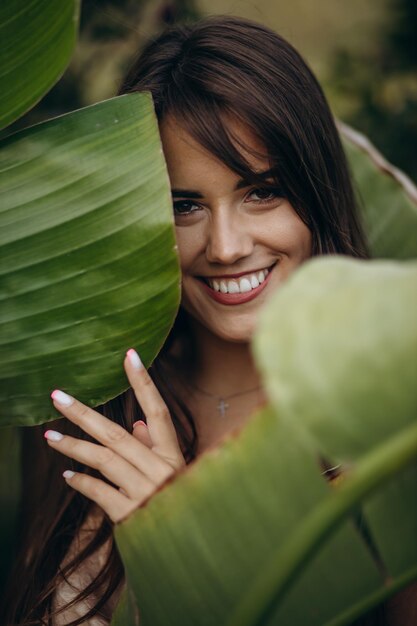 Portrait of beauriful woman by the green leaves