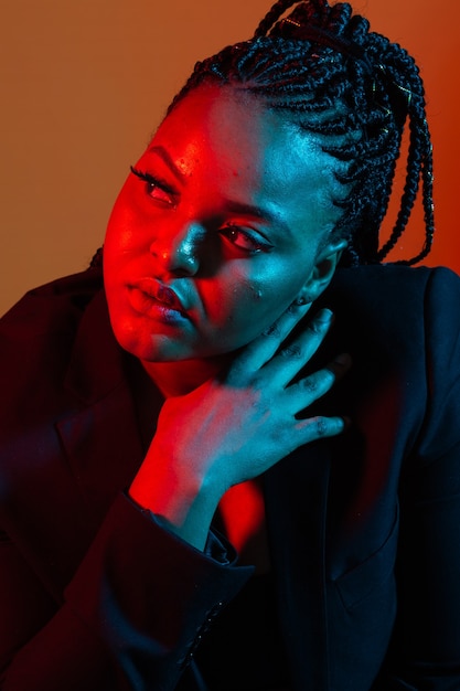 Portrait of beautiful african american female model posing. Colourful light.