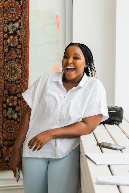 Portrait of beautiful african american woman laughing and looking at camera Female with big grin Carefree and cheerful lady having fun at home in morning