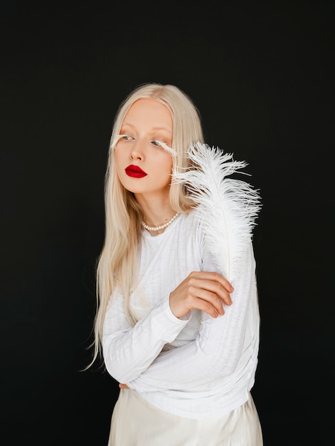 Portrait of beautiful albino woman with white feather