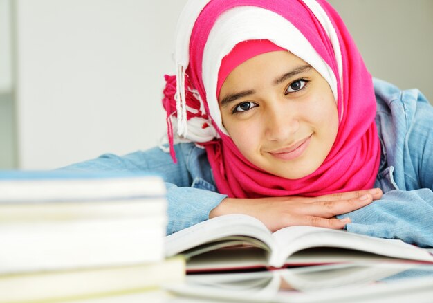 Photo portrait of beautiful arabic muslim girl with books