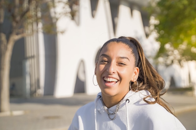 Portrait of a beautiful arabic woman smiling and looking at camera outdoors in the student campus du