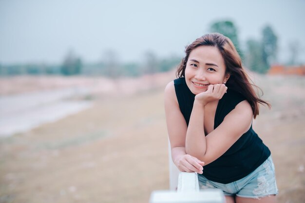 Портрет красивой азиатской шикарной девушки позирует для снимка на открытом воздухеСтиль жизни подростков из ТаиландаСовременная женщина счастлива концепция