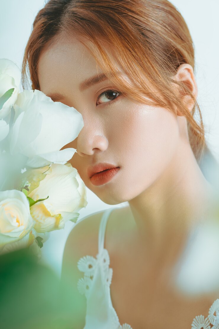 Photo 白色背景上孤立的漂亮的亞洲女孩手中花束的肖像