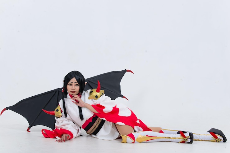 Photo 美しいアジアの女の子の肖像画は白い背景にコスプレゲームのアニメーションを着用しますタイの人々赤い布の悪魔のスタイル