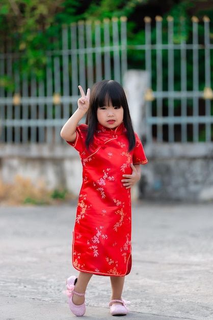 Portrait beautiful asian little girl in Cheongsam dressThailand peopleHappy Chinese new year conceptHappy Little asian girl in chinese traditional dress