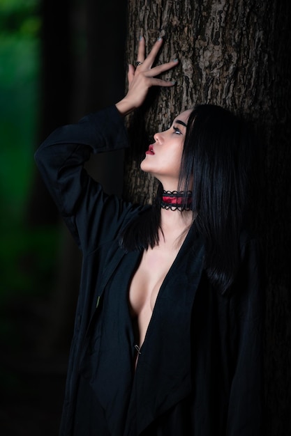 아름 다운 아시아 섹시 한 여자의 초상화는 빗자루 할로윈 축제 개념으로 검은 마녀 의상을 입고