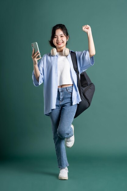 portrait of a beautiful asian student on a green background