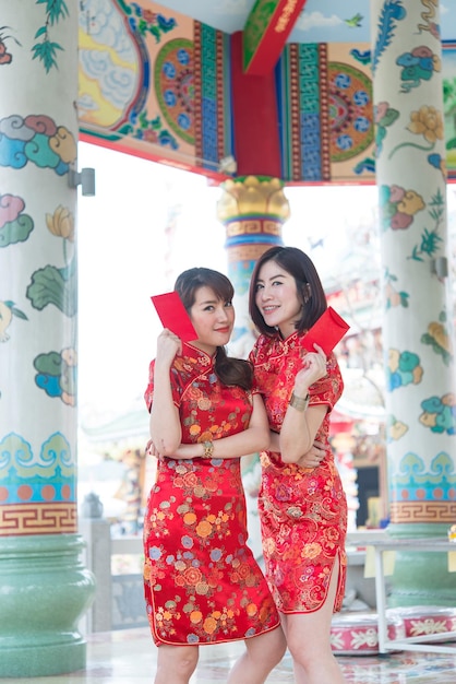 Portrait of beautiful asian woman in Cheongsam dress with Red envelope in handThailand peopleHappy Chinese new year concept