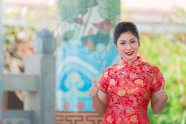 チャイナドレスの美しいアジアの女性の肖像画タイの人々幸せな中国の旧正月のコンセプト