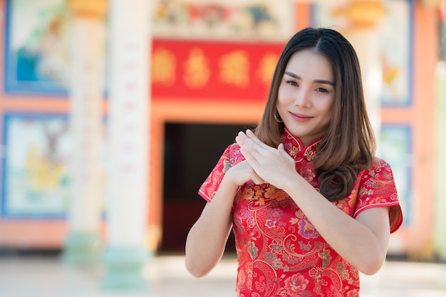 チャイナドレスの美しいアジアの女性の肖像画タイの人々幸せな中国の旧正月のコンセプト