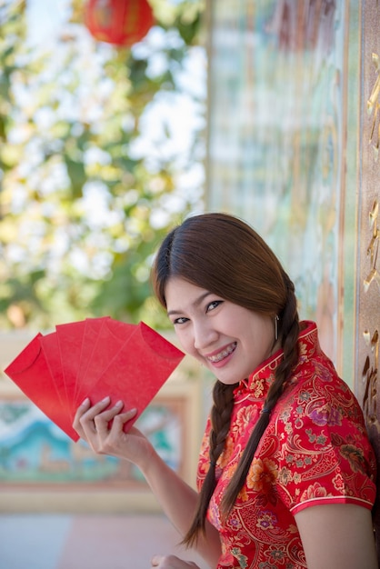 チャイナドレスの美しいアジアの女性の肖像画タイの人々幸せな中国の旧正月のコンセプト