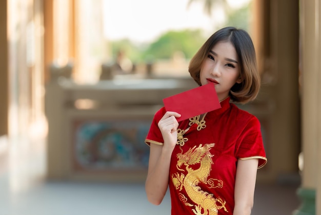 Portrait beautiful asian woman in Cheongsam dressThailand peopleHappy Chinese new year conceptHappy asian lady in chinese traditional dress