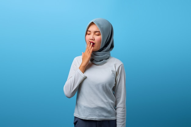 Portrait of beautiful Asian woman feeling sleepy and covering mouth with hand