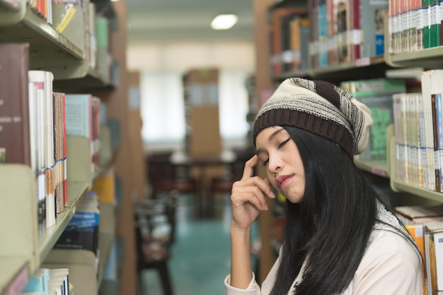 Женщина портрета красивая азиатская в библиотеке
