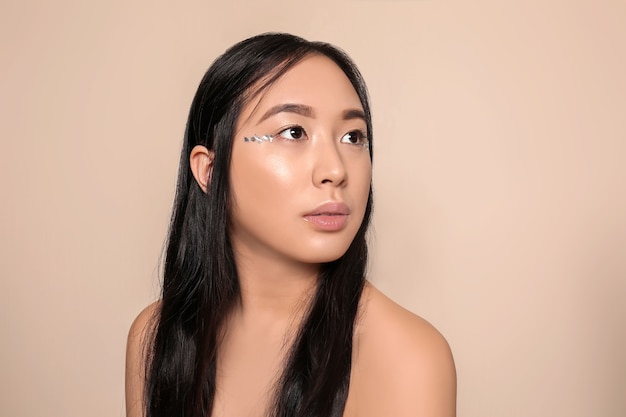 Portrait of beautiful Asian woman on light background