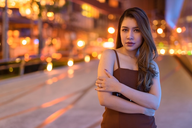 Portrait of beautiful Asian woman outdoors in Bangkok, Thailand at night