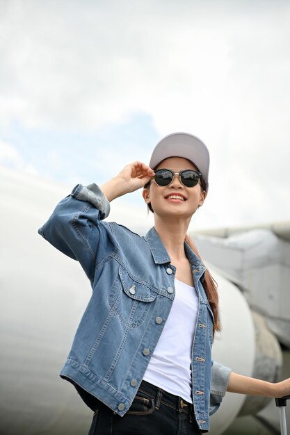 Portrait of a beautiful asian woman posing outside in front of the plane travelling by airplane