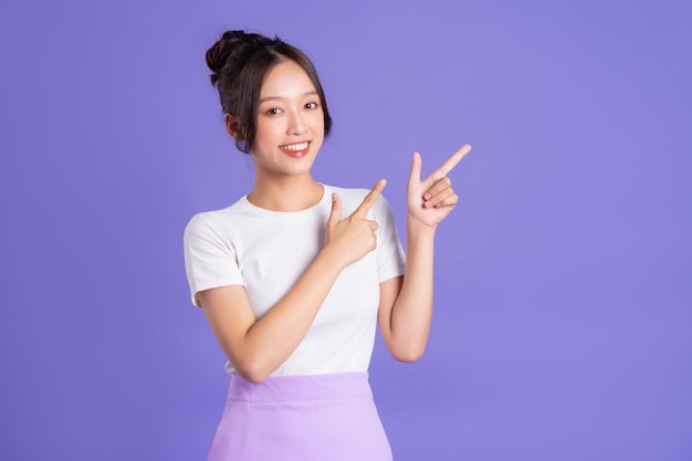 Portrait of a beautiful Asian woman posing on a purple background