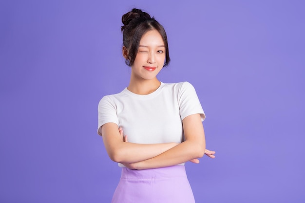 Photo portrait of a beautiful asian woman posing on a purple background