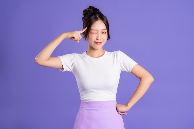 Portrait of a beautiful Asian woman posing on a purple background