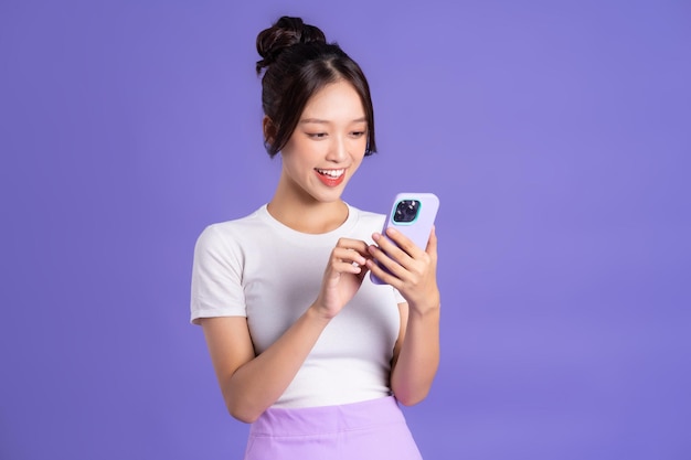 Портрет красивой азиатки, позирующей на фиолетовом фоне