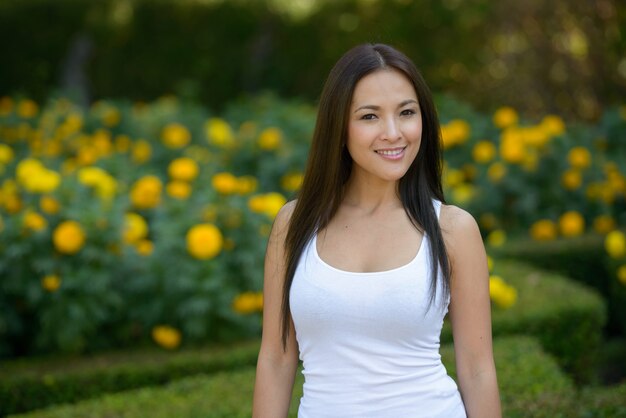 Portrait of beautiful Asian woman relaxing at the park outdoors