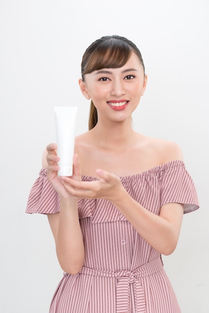 Portrait beautiful asian woman showing product with white cosmetic tube plastic