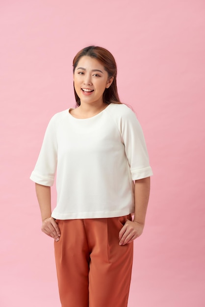 Portrait of beautiful asian woman smiling against pink wall