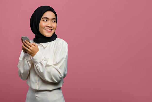 Portrait of beautiful Asian woman smiling and holding smartphone