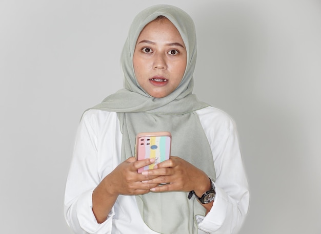 Portrait of a beautiful Asian woman speechless while holding a cell phone