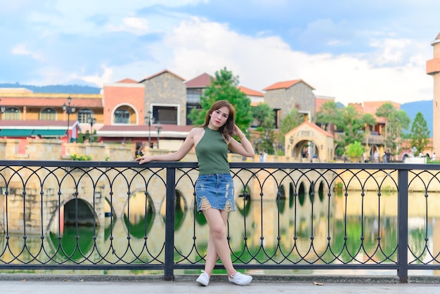Portrait of beautiful asian woman at tuscany cityThailand people pose for take a photo can see bridge and river