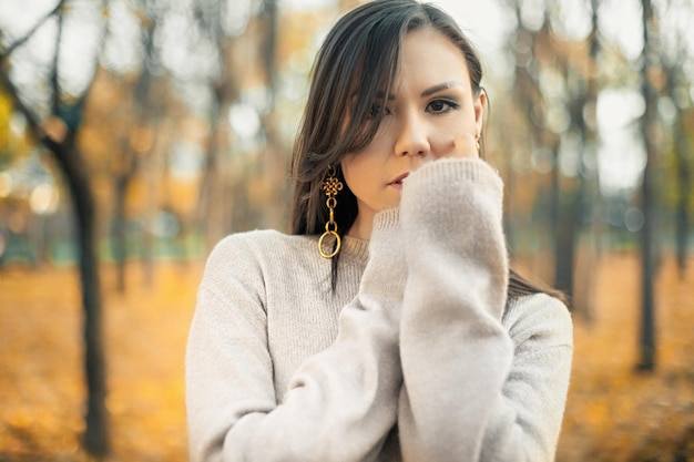 Ritratto di una bella donna asiatica che cammina all'aperto bella donna in un maglione moda ritratto di bella donna alla moda all'aperto