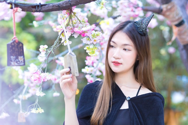 나무 간판을 들고 서 있는 좋은 피부와 긴 머리를 가진 아름다운 아시아 여성 초상화