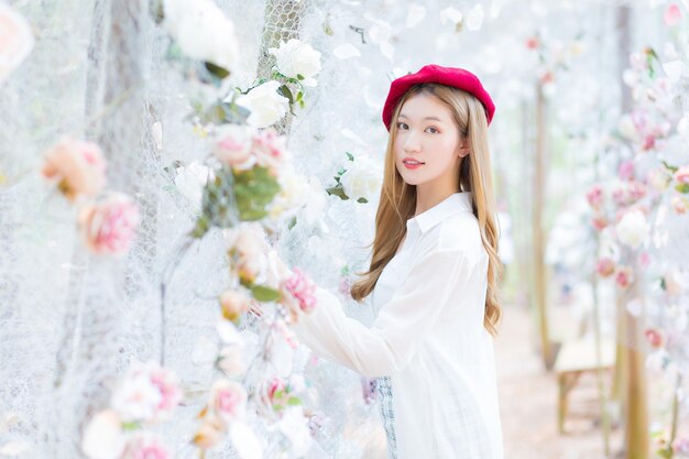 Portrait beautiful Asian woman with good skin who wears a white shirt  while in the flower garden