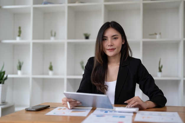 Portrait beautiful asian woman working about financial with business report and calculator financial or accounting concept