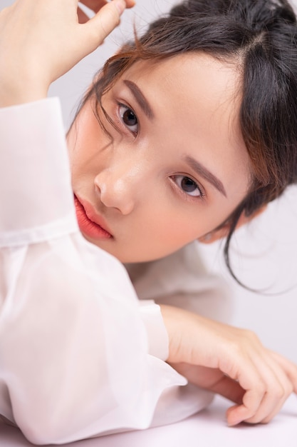 Portrait of beautiful and attractive Asian woman against white background