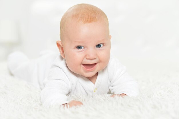 Portrait of beautiful baby boy on bed