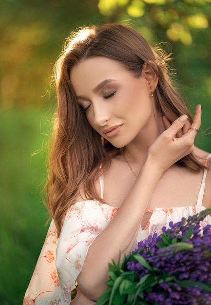 Portrait of a beautiful beautiful girl in a lupine field