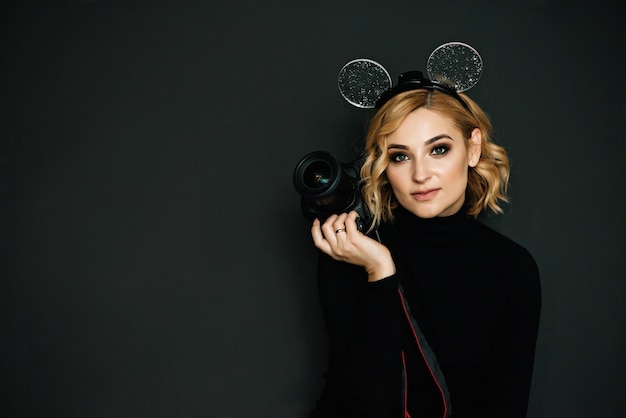 Portrait of a beautiful blonde photographer girl with a camera in hands