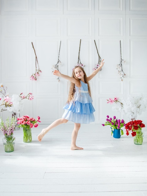 Portrait of a beautiful blueeyed girl little among spring flowers Mothers Day Womens Day Easter