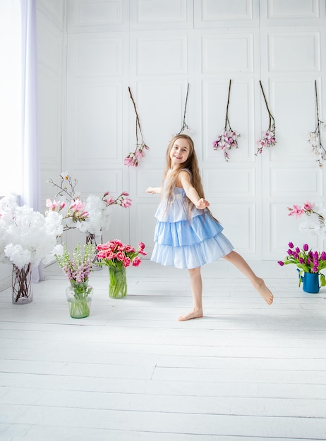 Portrait of a beautiful blueeyed girl little among spring flowers Mothers Day Womens Day Easter