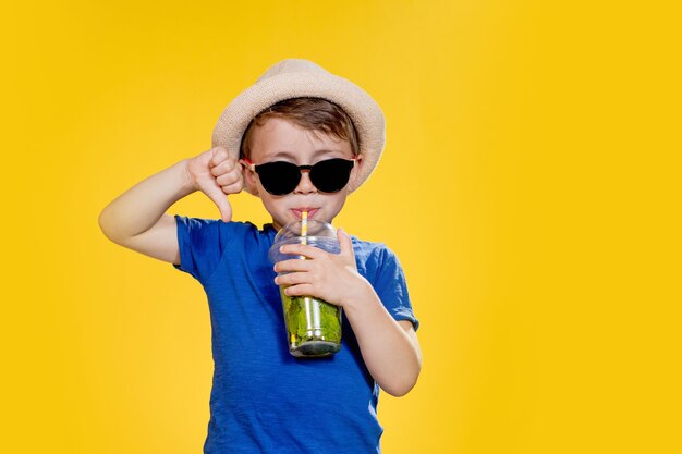 Portrait of a beautiful boy Happy child European boy in a hat summer tshirt with lemonade 