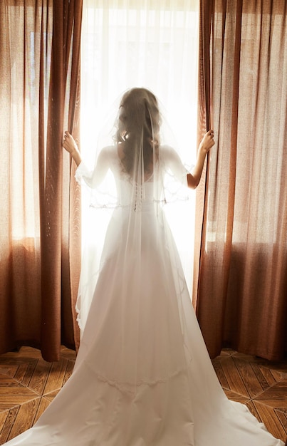 Portrait of the beautiful bride against a window