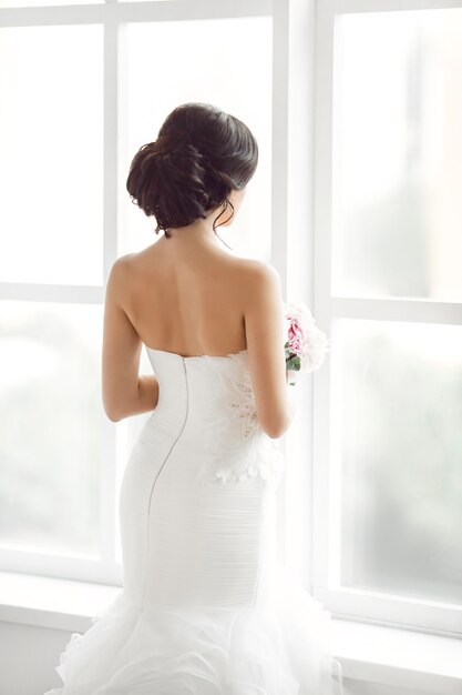 Portrait of a beautiful bride looking at window shot from behind