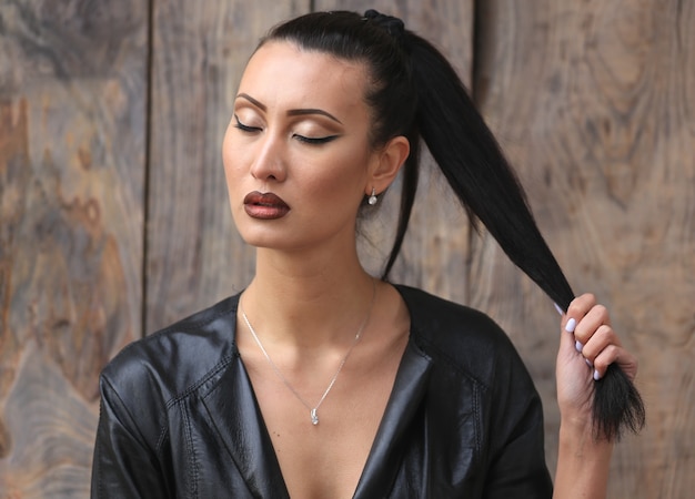 portrait of a beautiful brunette girl in a black leather jacket