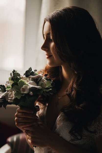 Ritratto di una sposa bella ragazza bruna con un bouquet