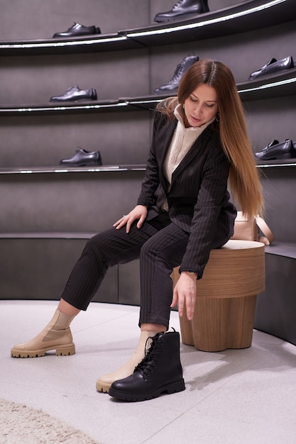 Portrait of beautiful brunette girl chooses shoes in the store